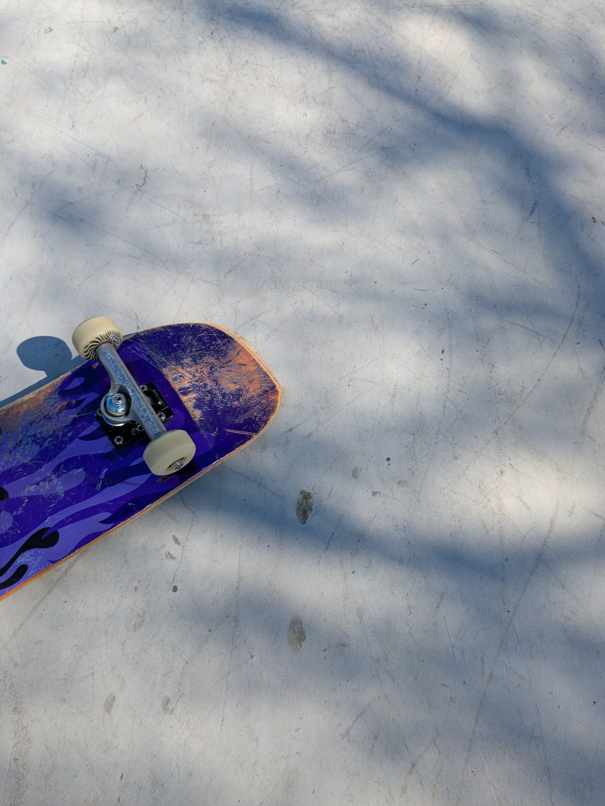 Purple skateboard with a pattern on a concrete surface